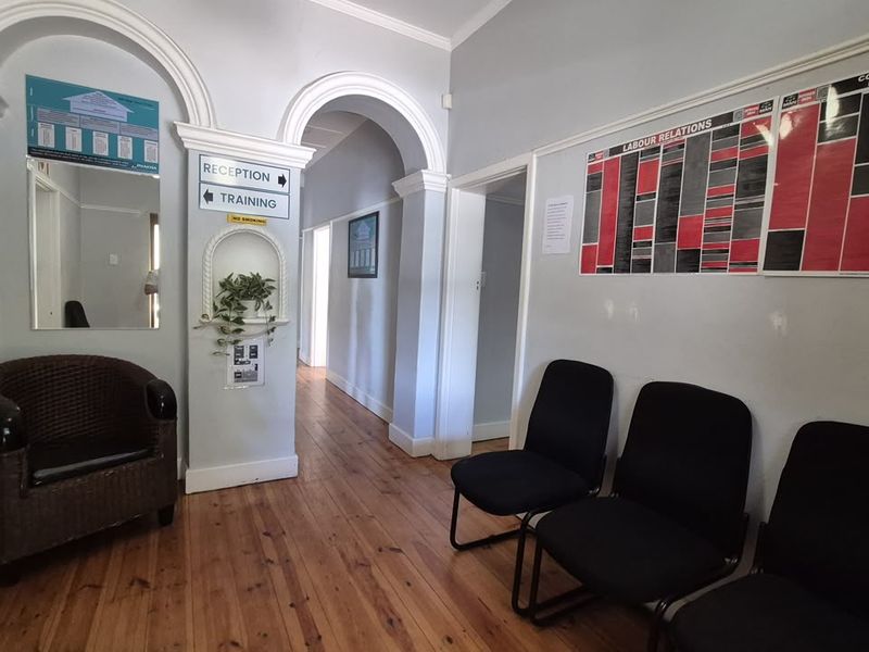 Office entrance area featuring hardwood flooring, decorative archways, and a built-in wall niche, providing a functional reception space.