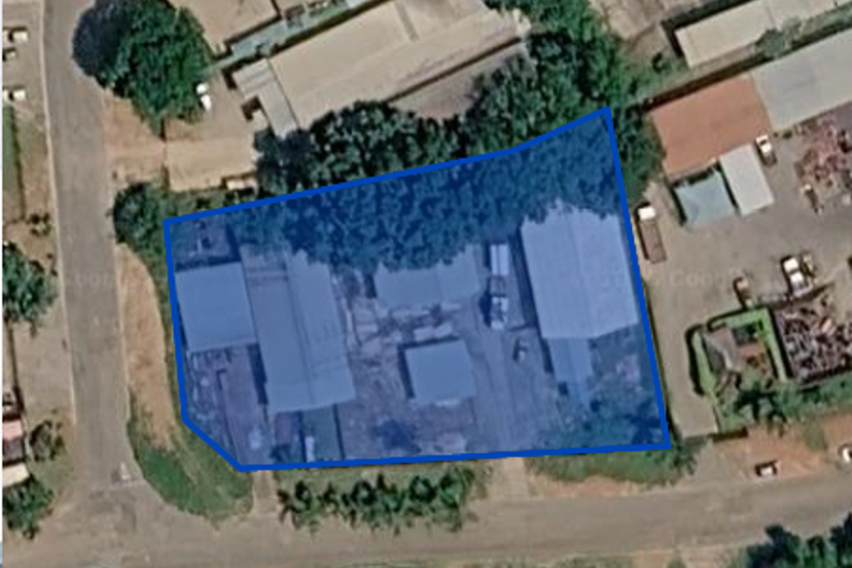 Aerial view of an industrial property featuring multiple warehouse structures and a central yard area.