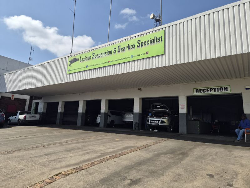 Industrial workshop facility featuring multiple service bays, a dedicated reception area, and a concrete forecourt for vehicle access.