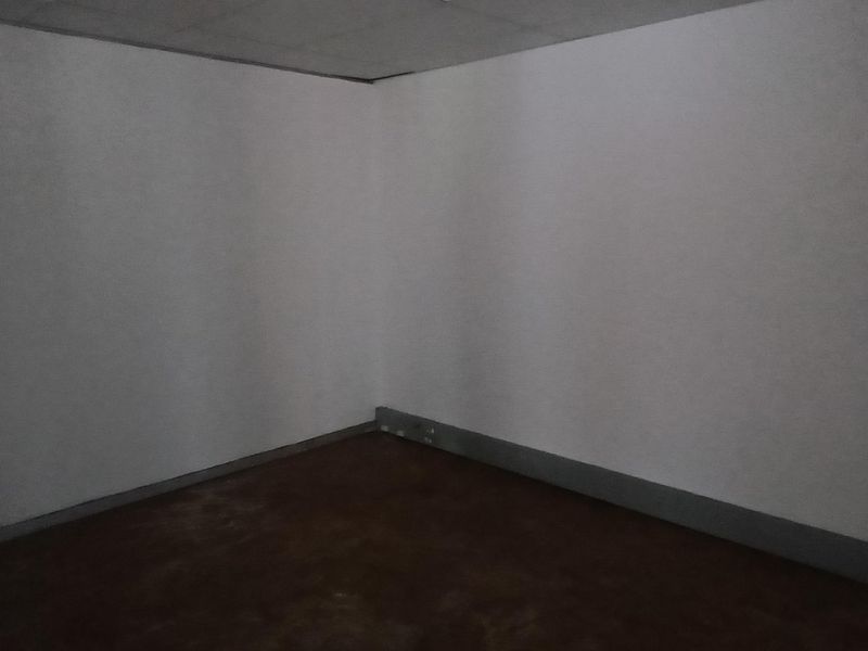 An empty, vacant office space featuring a suspended ceiling and dark flooring, ready for custom fit-out or renovation.