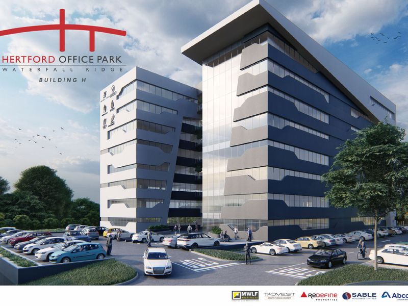 Modern multi-story office building facade at Hertford Office Park, featuring contemporary architectural design, glass curtain walls, and an extensive paved parking area.
