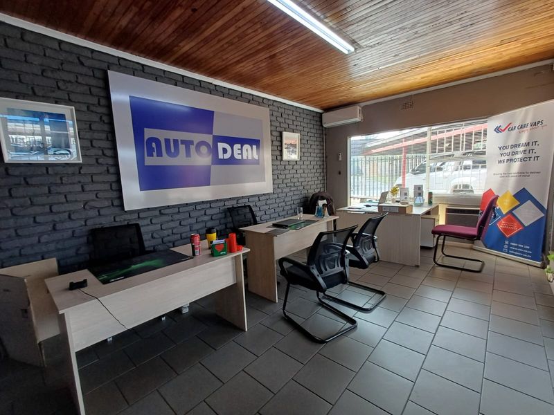 Commercial office space featuring exposed brick feature wall, timber-clad ceiling, tiled flooring, and large windows providing natural light.