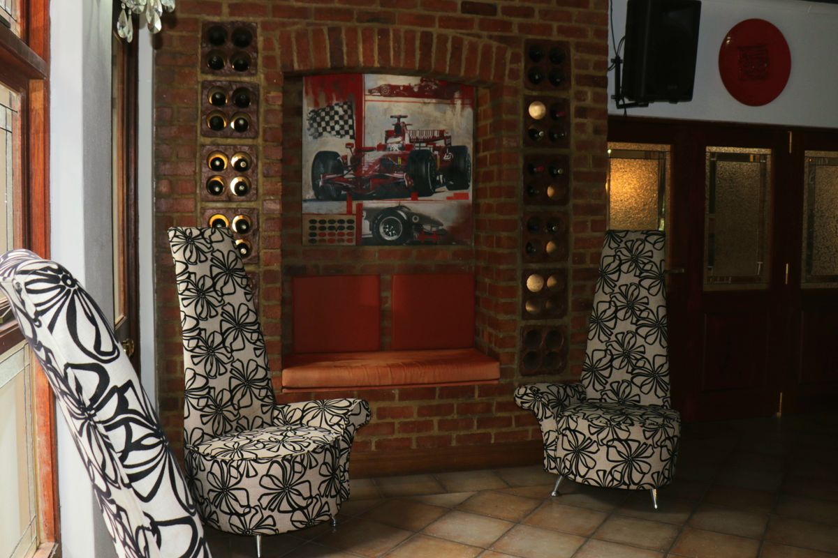 A cozy lounge area featuring a rustic exposed brick wall with integrated wine storage and a built-in bench seat.