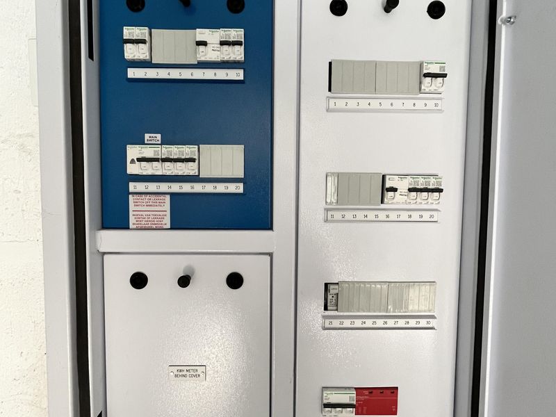A clean, well-maintained industrial electrical distribution board featuring multiple circuit breakers, a main switch, and a surge arrester.