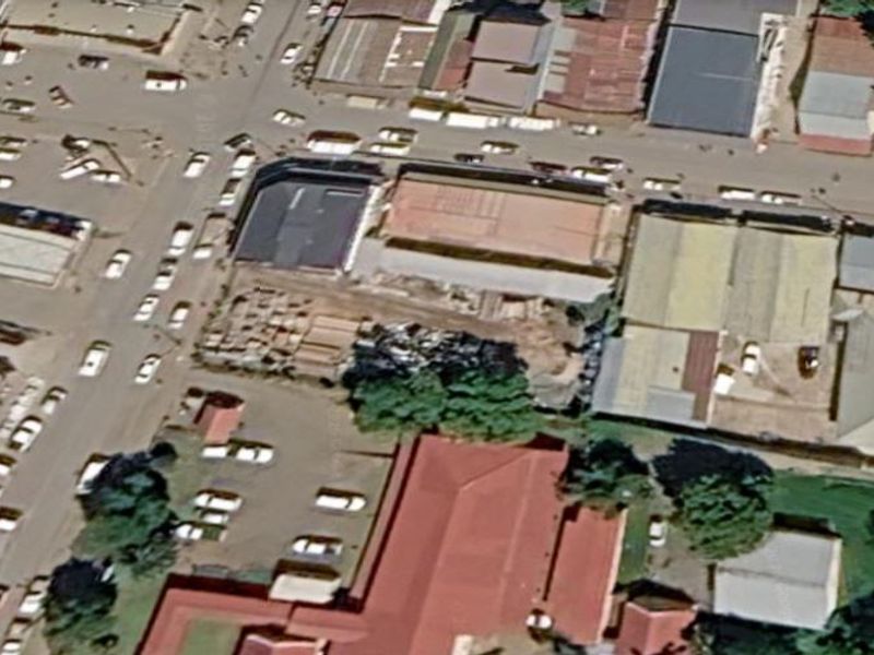 An aerial view of a commercial vacant land plot situated within a busy urban street network.
