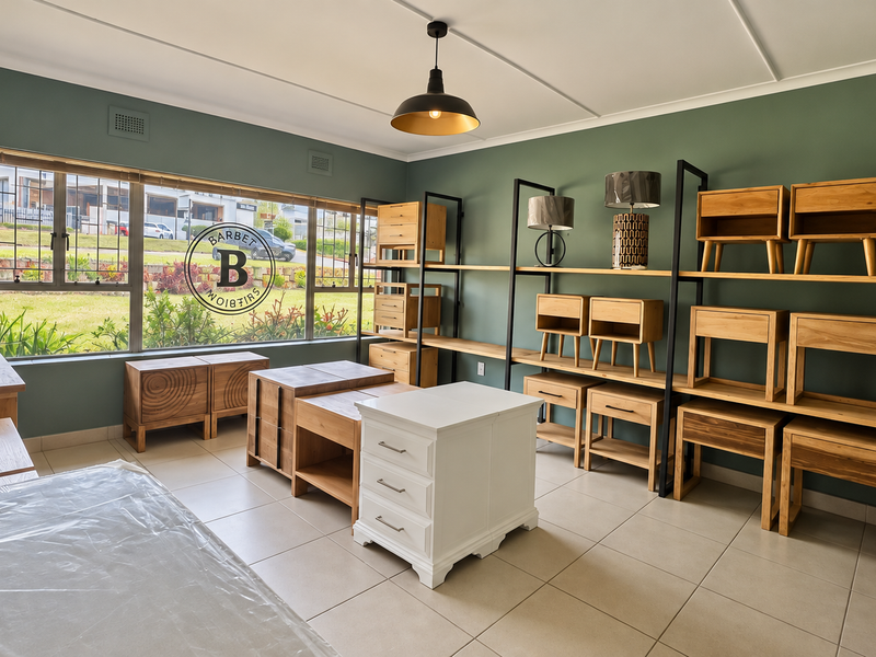 A bright, well-maintained office or showroom space featuring large windows, tiled flooring, and extensive built-in shelving units.
