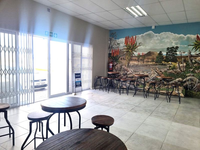 Open plan restaurant dining area featuring tiled flooring, suspended ceiling, and a large decorative wall mural.