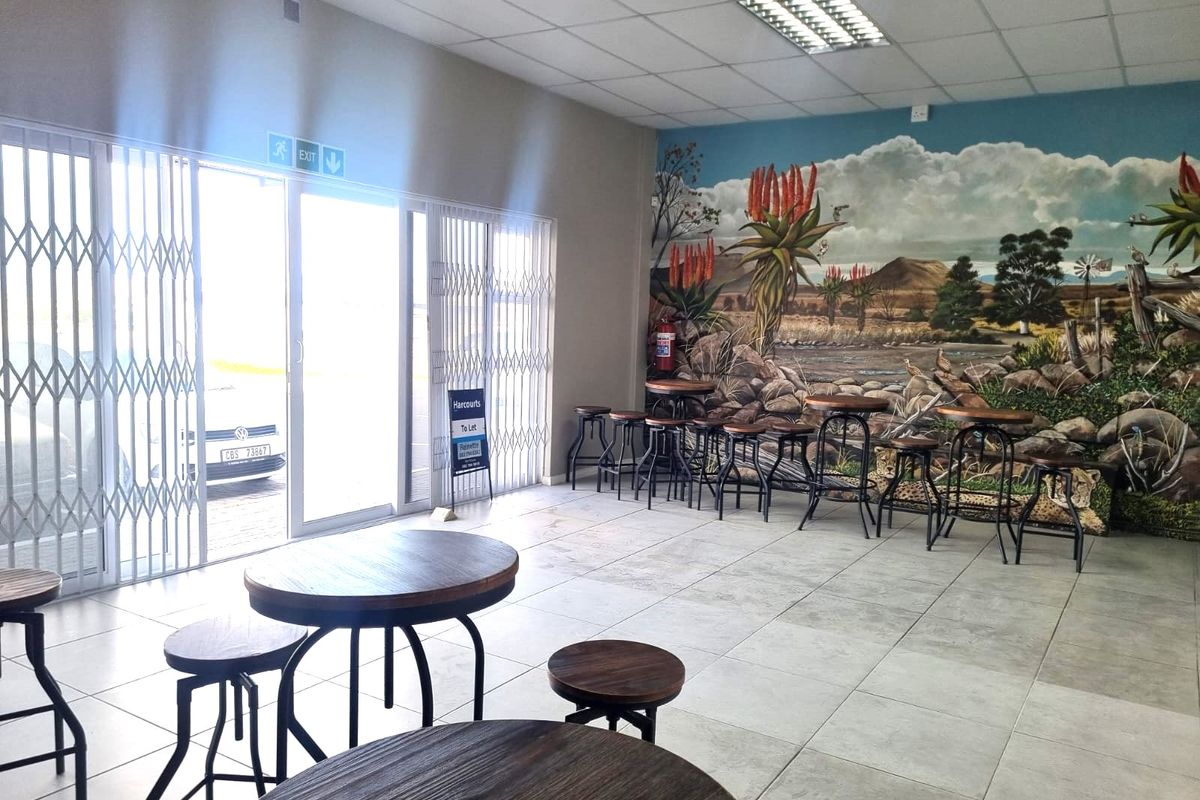 Open plan restaurant dining area featuring tiled flooring, suspended ceiling, and a large decorative wall mural.
