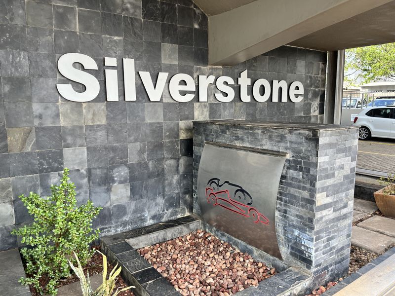 Professional office building entrance featuring a modern stone-clad facade, custom signage, and a decorative water feature.