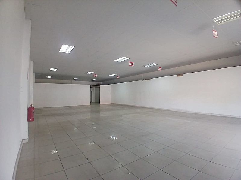 Spacious open-plan retail unit featuring tiled flooring, suspended ceilings with recessed lighting, and a clean, versatile layout suitable for various commercial business applications.
