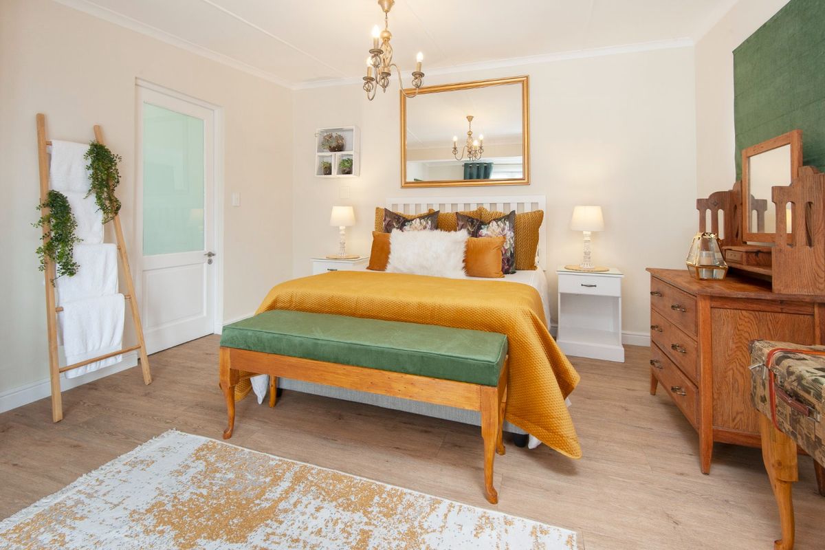 A well-maintained bedroom featuring laminate flooring, a frosted glass panel door, and coved ceiling details, offering a bright and comfortable living space.