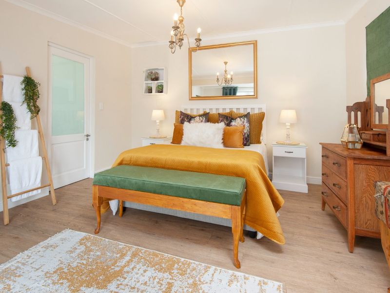 A well-maintained bedroom featuring laminate flooring, a frosted glass panel door, and coved ceiling details, offering a bright and comfortable living space.