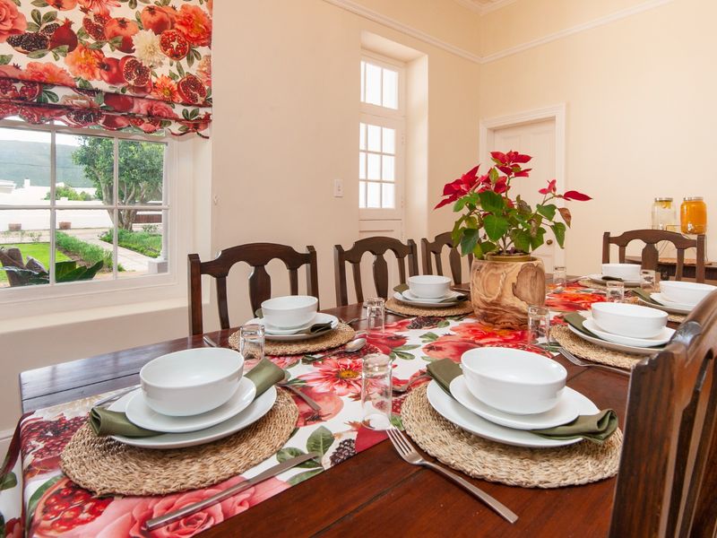 A well-maintained dining room featuring classic crown molding, a traditional sash window, and a panel door, providing a warm and inviting atmosphere.