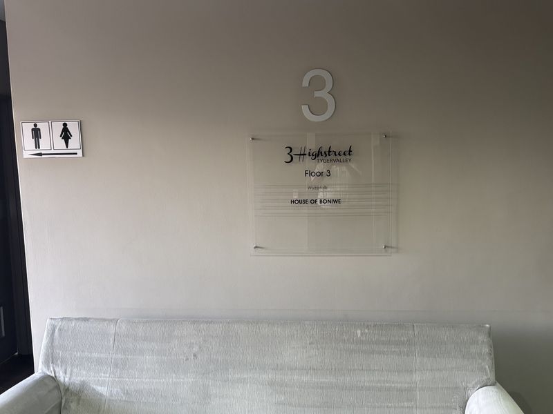 A clean office hallway featuring clear building directory signage and directional indicators for facilities on the third floor.