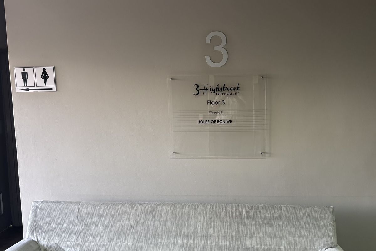 A clean office hallway featuring clear building directory signage and directional indicators for facilities on the third floor.