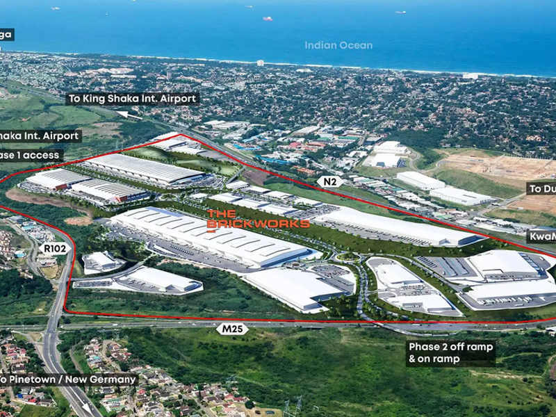 Aerial view of The Brickworks industrial development, highlighting warehouse facilities, strategic road access, and proximity to major transport routes and the Indian Ocean.