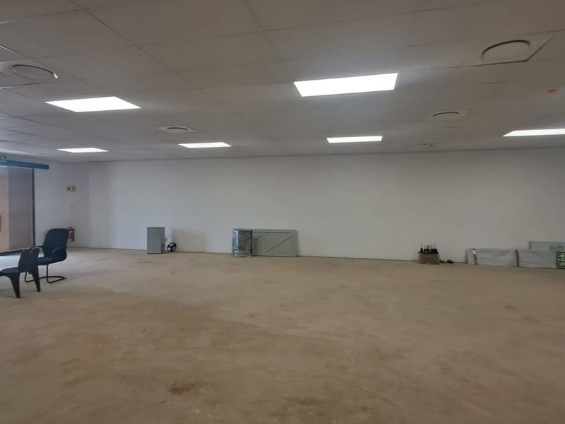 A spacious, open-plan retail area featuring a suspended ceiling with recessed lighting and unfinished concrete flooring, suitable for various commercial fit-out configurations.
