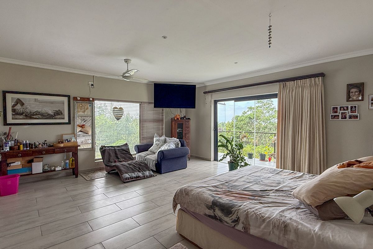 Spacious bedroom featuring tiled flooring, a ceiling fan, air conditioning, and large sliding glass doors providing access to an outdoor area.