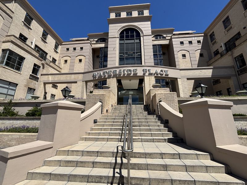 The front entrance of Waterside Place, featuring a grand stone staircase, stainless steel handrails, and a prominent brick facade.