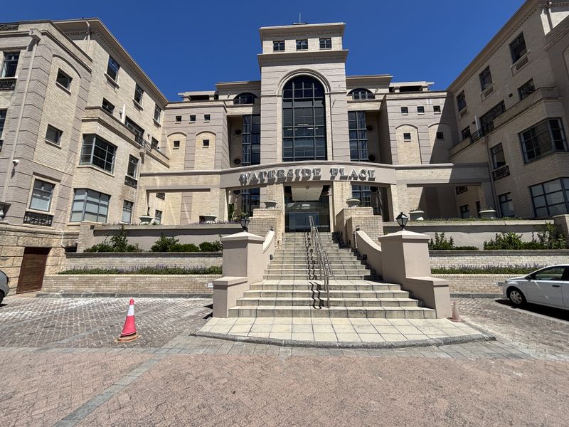 Front elevation of Waterside Place office building featuring a prominent brick facade, central stone staircase entrance, and paved driveway area.