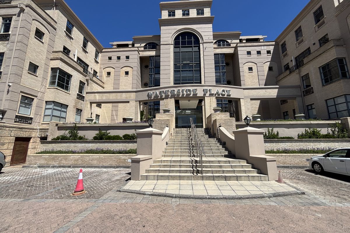 Front elevation of Waterside Place office building featuring a prominent brick facade, central stone staircase entrance, and paved driveway area.