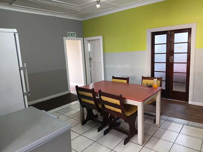 Dining area featuring tiled flooring, timber framed glass doors, and decorative ceiling molding, providing access to adjacent spaces.