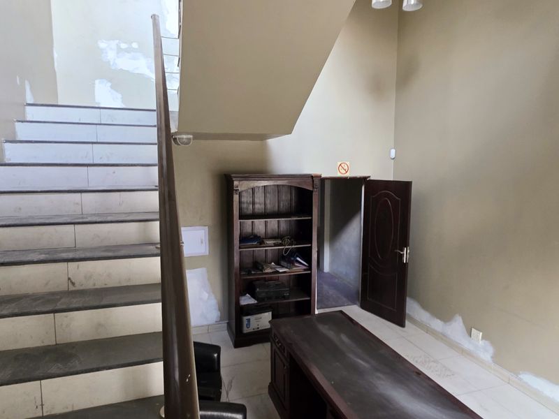 Entrance area featuring a staircase with tiled steps and access to an internal room, requiring cosmetic wall repairs and painting.
