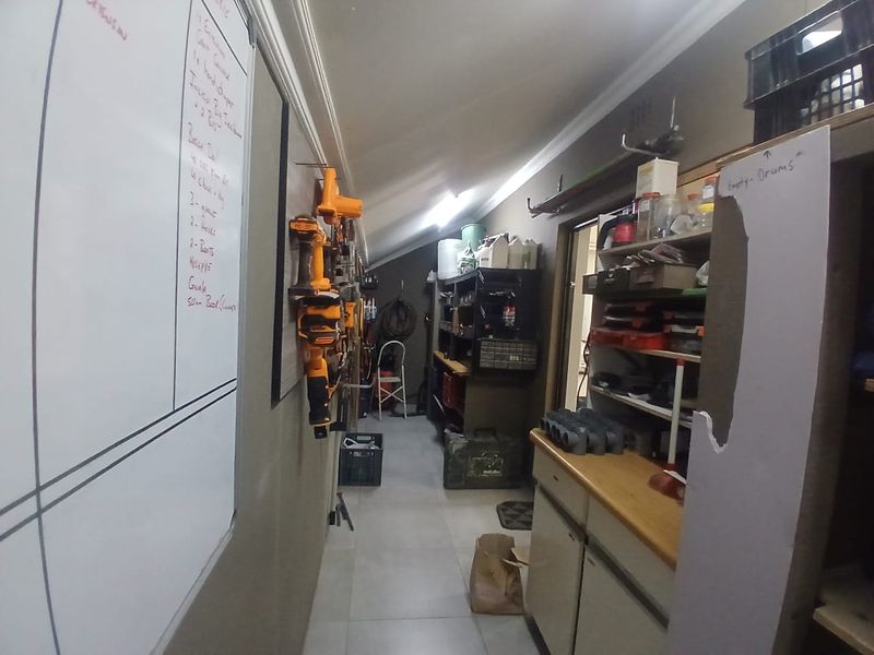 A functional utility or storage space featuring tiled flooring, built-in shelving units, and wall-mounted storage systems for equipment.