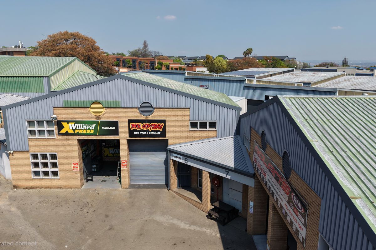 Aerial view of an industrial complex featuring multiple units with corrugated metal roofs, face brick facades, and roller shutter access doors.