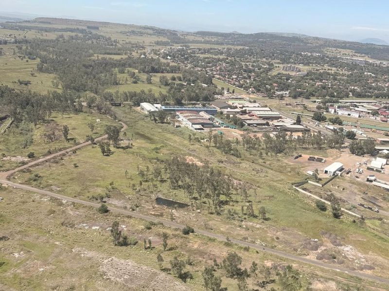 An aerial view of the industrial property site, showcasing the surrounding landscape, access roads, and proximity to the local area.