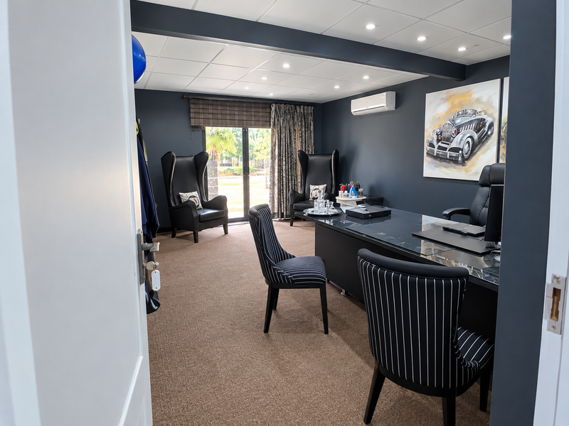 A professional office space featuring a suspended ceiling with recessed lighting, split-system air conditioning, and sliding glass doors leading to an outdoor area.