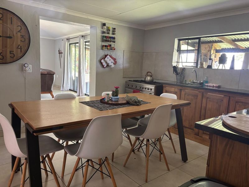 Open-plan kitchen and dining area featuring wooden cabinetry, a gas stove, and tiled flooring with direct access to an outdoor patio space.