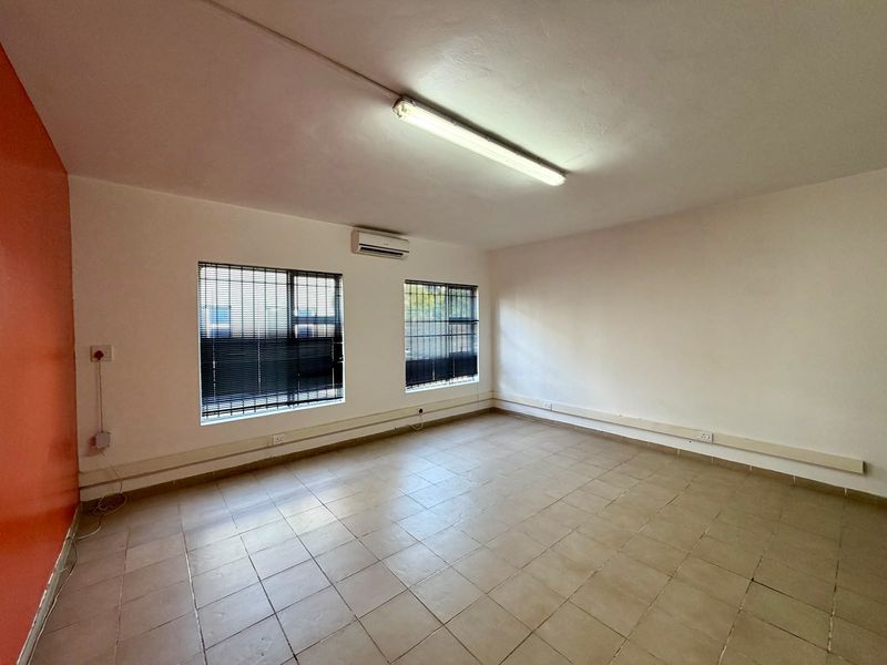 A vacant commercial office space featuring tiled flooring, air conditioning, and surface-mounted electrical trunking, suitable for a variety of business configurations.