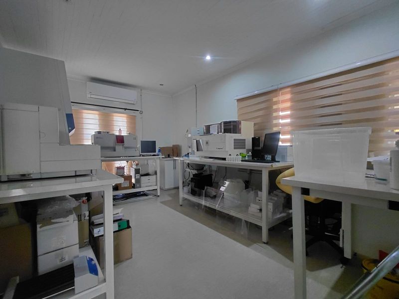 A functional commercial laboratory or office space equipped with air conditioning, window blinds, and recessed lighting, suitable for professional or technical operations.
