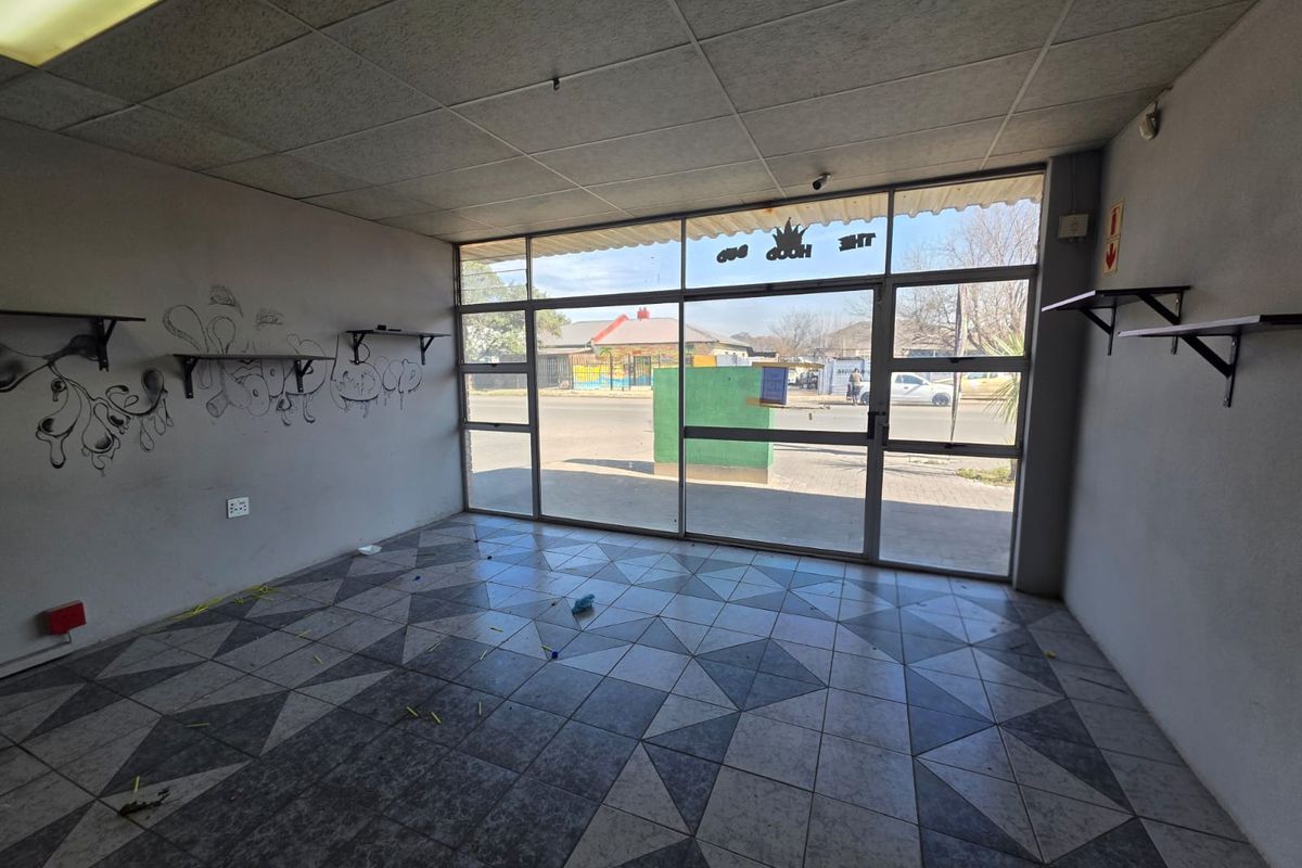 Vacant retail storefront featuring large glass display windows, tiled flooring, and a suspended ceiling, offering a blank canvas for commercial renovation.