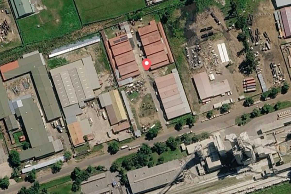 Aerial view of a commercial industrial complex featuring multiple warehouse structures, access roads, and surrounding yard space.
