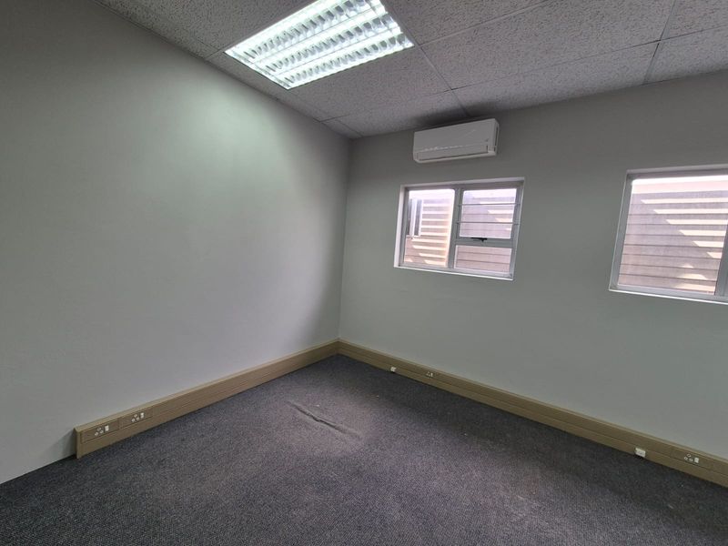A vacant office space featuring carpeted flooring, integrated electrical trunking, split-system air conditioning, and recessed ceiling lighting.