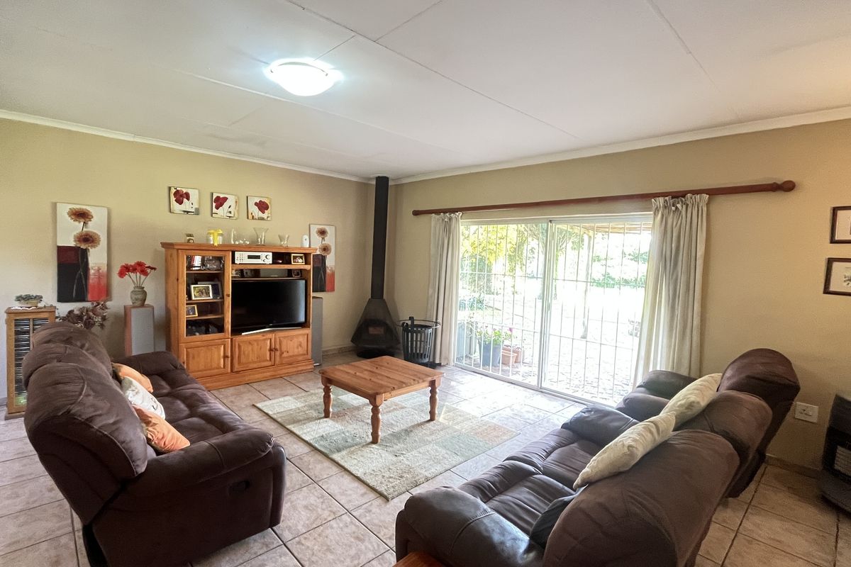 Spacious living room featuring tiled flooring, a built-in fireplace, and large sliding glass doors providing direct access to the outdoor patio area.