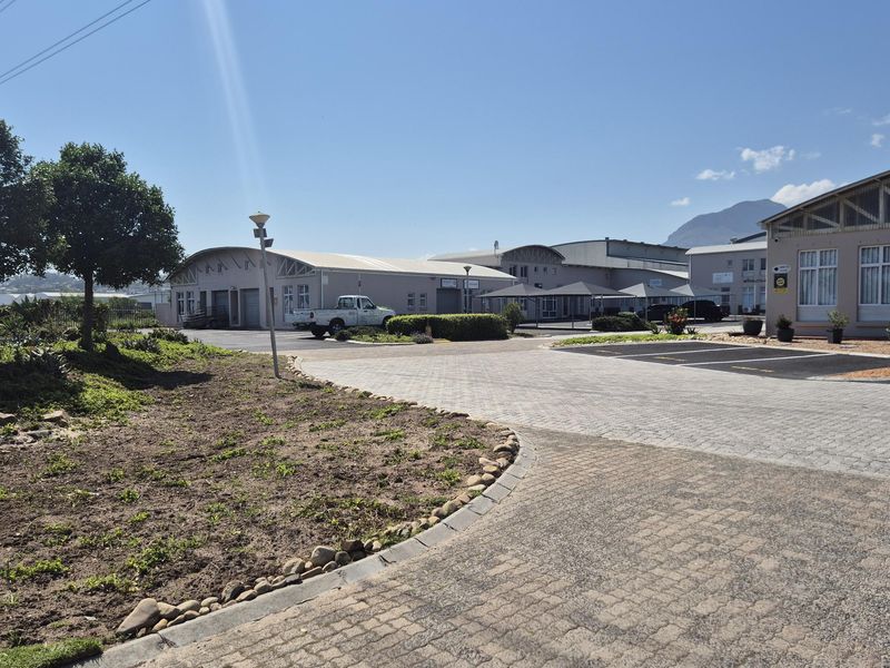 Exterior view of an industrial business park featuring paved driveways, warehouse units with roller shutter doors, and landscaped grounds.