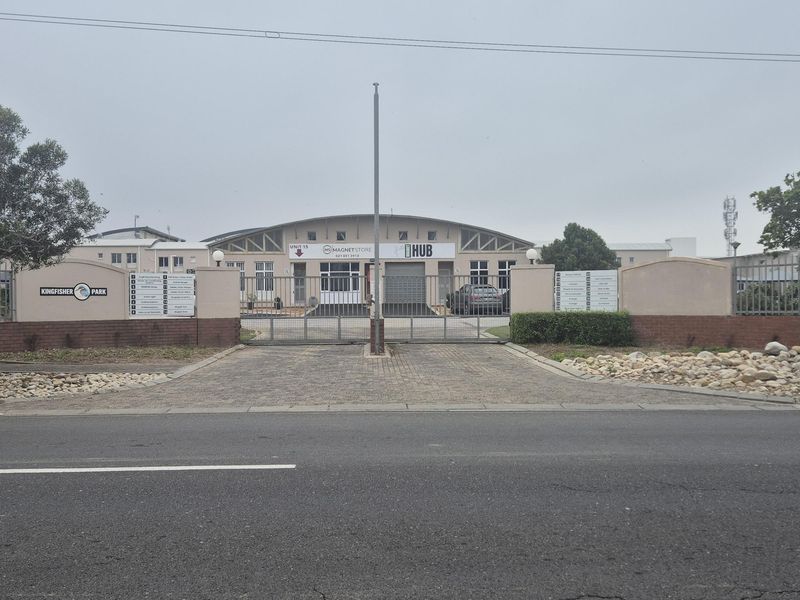 Front entrance view of Kingfisher Park industrial complex featuring a secure gated access point, paved driveway, and industrial unit facade.