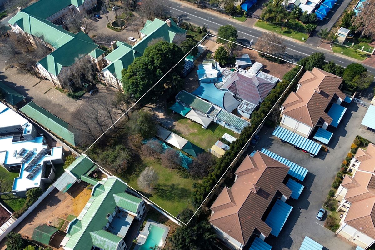 Aerial view of the office property, highlighting the building layout, surrounding grounds, and parking facilities within the demarcated boundary.