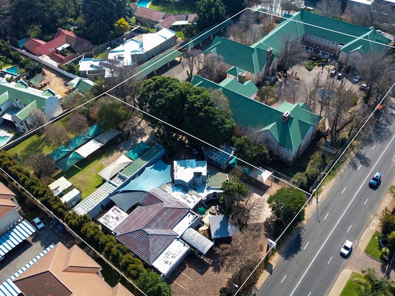 Aerial view of the office property complex, showcasing the building layout, green roof structures, parking areas, and surrounding grounds.