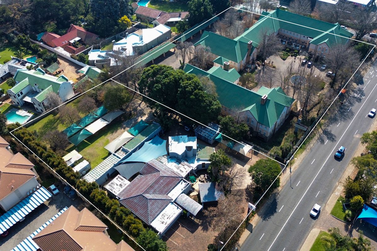 Aerial view of the office property complex, showcasing the building layout, green roof structures, parking areas, and surrounding grounds.
