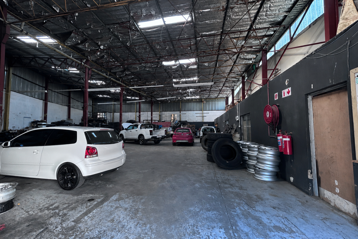 Spacious industrial garage facility featuring exposed steel roof trusses, concrete flooring, and integrated fire safety equipment.