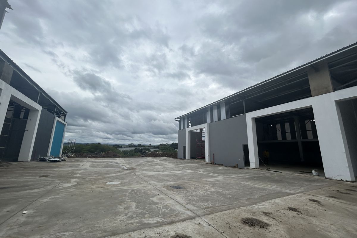 Spacious industrial yard area situated between two modern warehouse structures with high-clearance access points and concrete hardstand flooring.