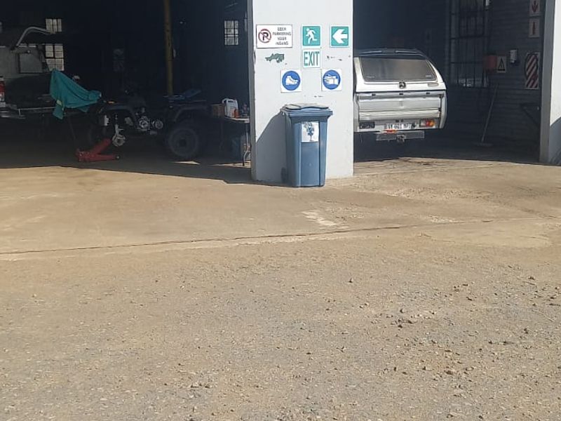Commercial garage facility featuring dual roller shutter door access and a concrete apron, suitable for automotive or industrial storage use.