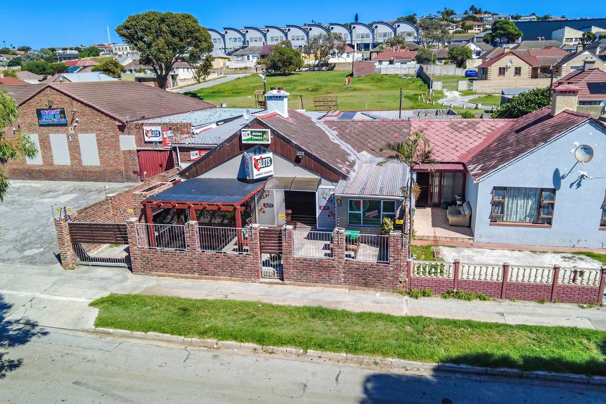 Aerial view of a commercial tavern property featuring a brick perimeter wall, outdoor patio area, and tiled roof structure in a suburban setting.