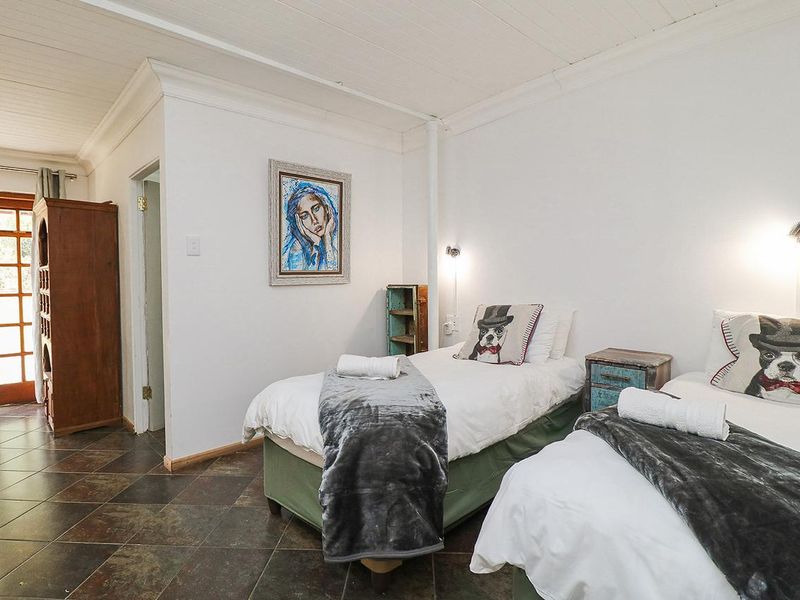 A bedroom featuring tiled flooring, a timber ceiling, and direct access to an outdoor area through a glass panel door.
