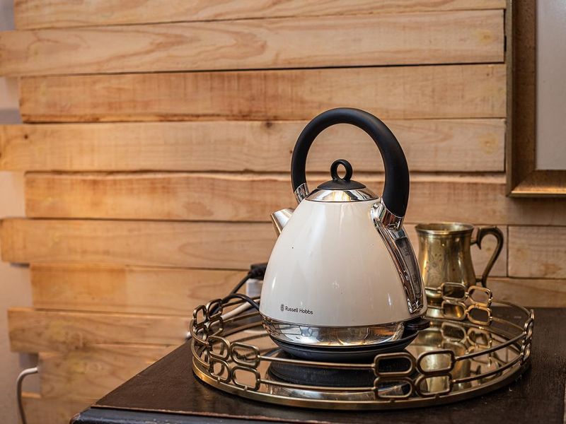 A close-up view of a tea station featuring decorative timber wall cladding as a backdrop.