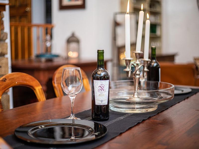 A warm and inviting dining area featuring a stone fireplace, perfect for intimate meals and gatherings in this guest house setting.